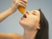 Nude teen drinking orange juice